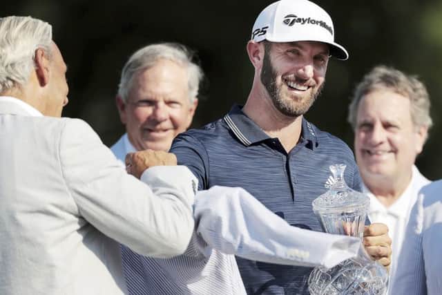Dustin Johnson is presented with his trophy and winner's jacket after winning the St. Jude Classic.Picture: Jim Weber/The Commercial Appeal via AP