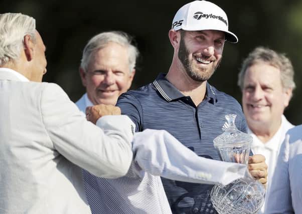 Dustin Johnson is presented with his trophy and winner's jacket after winning the St. Jude Classic.Picture: Jim Weber/The Commercial Appeal via AP