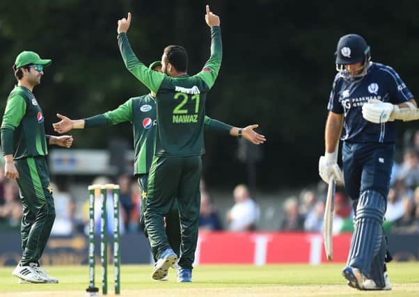 Pakistan's Mohammad Nawaz, centre,  celebrates aftertaking the wicket of Scotland captain Kyle Coetzer.
