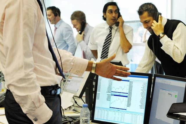 Currency traders at Worldwide Currencies Ltd in London's Canary Wharf stand at their desks to cold call during 'power hour'. So-called 'robo-trading' is reducing demand for such practices. Picture: PA