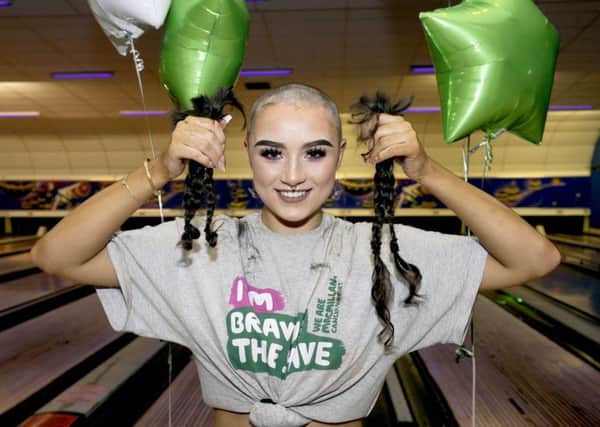 Morven holds up her hair after the shave, which will be donated to the Little Princess Trust