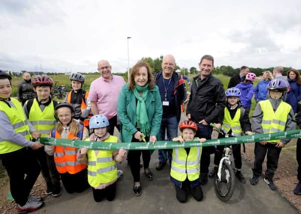 Councillor Lesley Macinnes and Sustrans Scotland national director John Lauder (in pink shirt) with youngsters from Danderhall Primary Scholl, Midlothian, opening the new cycle path.
 Photo by Colin Hattersley