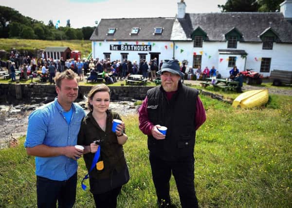 Ulva residents Rhuri Munro and his wife Rebecca and Barry George celebrate the buyout last week. Picture: Andy Buchanan/Getty Images