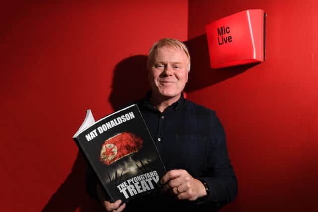 Dave McKinnon with a copy of his novel, written under the pen name Nat Donaldson. Picture: John Devlin