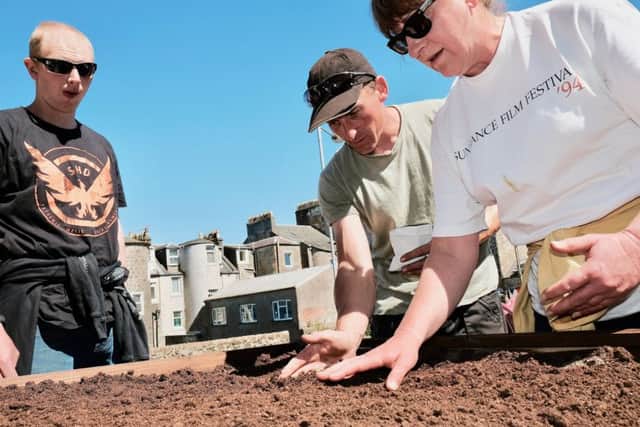 Ronnie Armstrong (centre) Head Gardener from Bute Produce helping volunteers to plant seeds, at Chapel Hill Community Garden. Photo by Iain Cochrane.