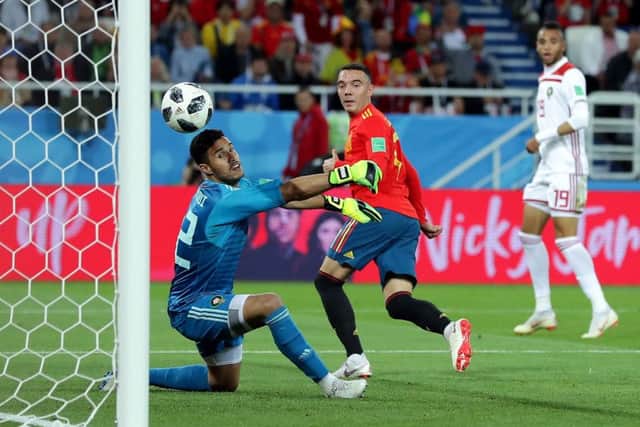 Iago Aspas of Spain backheels a late equaliser past Monir El Kajoui of Morocco to earn Spain a 2-2 draw and secure top spot in Group B. Picture: Getty.