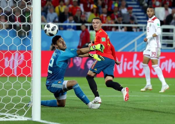 Iago Aspas of Spain backheels a late equaliser past Monir El Kajoui of Morocco to earn Spain a 2-2 draw  and secure top spot in Group B. Picture: Getty.