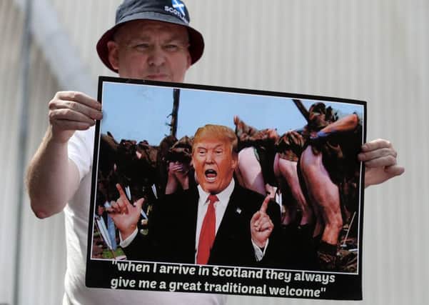A protester shows what he thinks Scotland makes of Donald Trump (Picture: John Devlin)