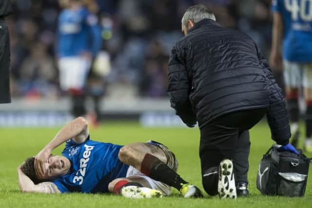 A stricken Ryan Jack receives treatment on the Ibrox turf after the challenge. Picture: SNS Group