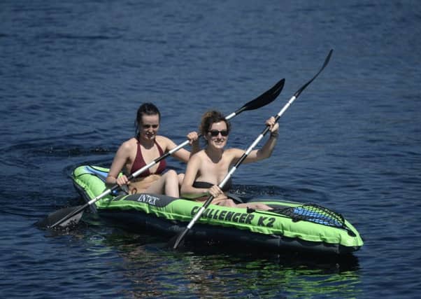 Left to right; Laura Mair, 26, Martha Garcia, 26, enjoy the sun at Loch Lomond at Luss as temperatures reach 29c. Picture: SWNS