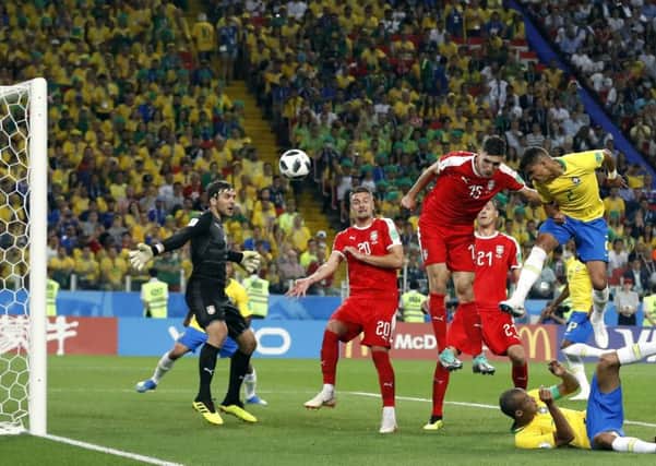 Thiago Silva heads home Brazils second goal to seal victory over Serbia and confirm his sides place at the top of Group E. Picture: AP
