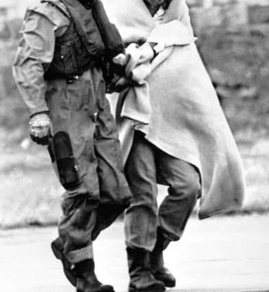 Royal Air Force Air Load Master Bob Pountney helping a survivor as he arrives at Aberdeen Royal Infirmary after the explosion disaster on the North Sea oil production platform Piper Alpha.