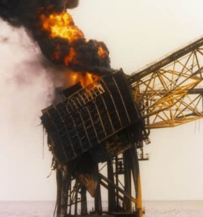 Smoke  billowing from the burning wreckage of the Piper Alpha oil production platform.