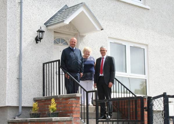 Melvilles Neil Edgar and Andrew Noble, with Cathy Hanlan at her recently-insulated Easthouses home.