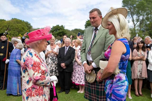 Britain's Queen Elizabeth II meets former Scotland ruby union player Doddie Weir and his wife Kathy (R) as she hosts the annual garden party at the Palace of Holyroodhouse in Edinburgh on July 4, 2018.