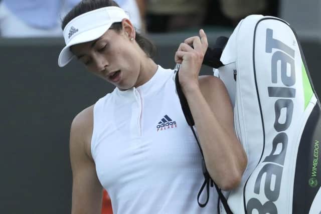 Defending champion Garbine Muguruza leaves the court after losing to Alison Van Uytvanck of Belgium. Picture: Ben Curtis/AP