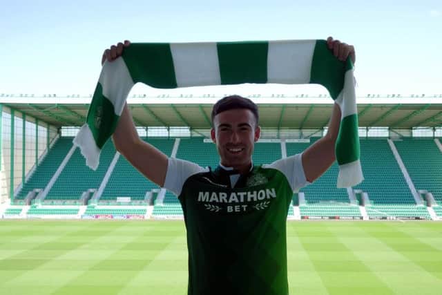 Stevie Mallan holds a Hibs scarf aloft after completing his move to Easter Road. Picture: Hibs TV