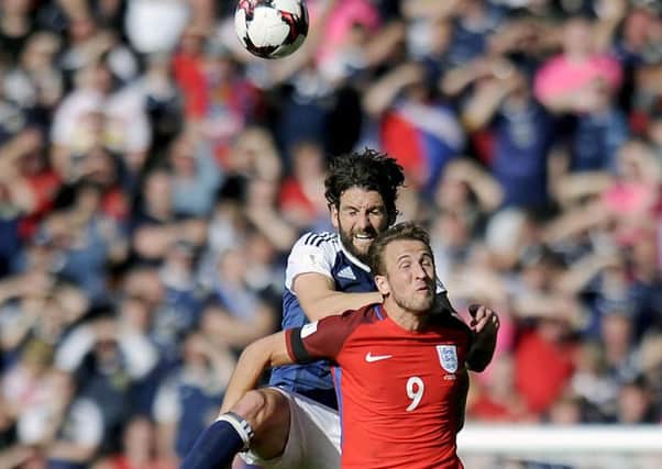 Harry Kane is out-jumped by Scotland's Charlie Mulgrew during the 2-2 draw at Hampden last year (Picture: Michael Gillen)