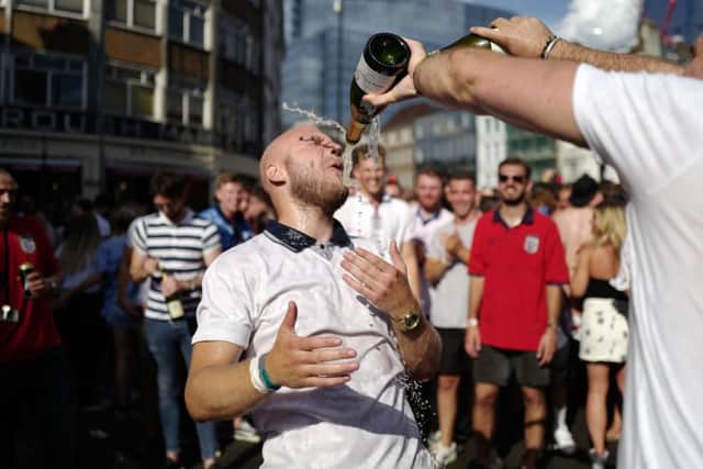 A man is drenched in champagne in the street beside Borough Market as England fans celebrate their win over Sweden. Picture: Akmentolga Akmen/Getty Images