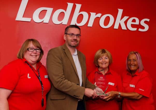 Donald Morrison presents the ABB Scotlands Community Betting Shop of the                                             Year award to the Ladbrokes Dunoon team of Yvonne Love, Caroline Guchine and Lucy Richmond