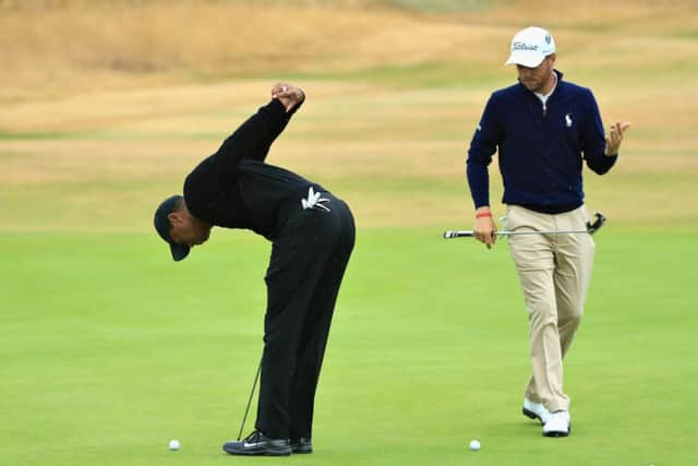 Tiger Woods puts his troublesome back through a stretching exercise during putting practice with compatriot Justin Thomas at Carnoustie. Picture: Sam Greenwood/Getty Images