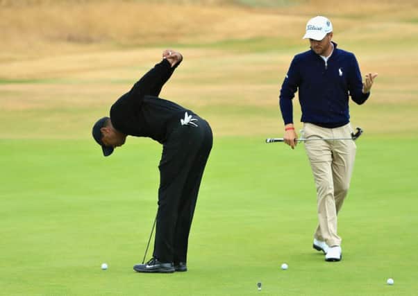 Tiger Woods puts his troublesome back through a stretching exercise during putting practice with compatriot Justin Thomas at Carnoustie. Picture: Sam Greenwood/Getty Images