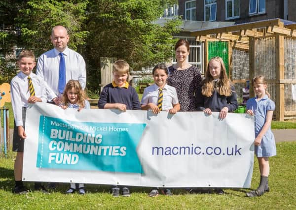 Jamie McLean and Susan Wilson of Mactaggart & Mickel Homes pictured with Eaglesham Primary School pupils (L-R) Nathan Clough P6, Jessica Marchant P2, Matthew McVey P5, Milla Perry P6, Niamh Moore P7 and  Isla Wilson P3.