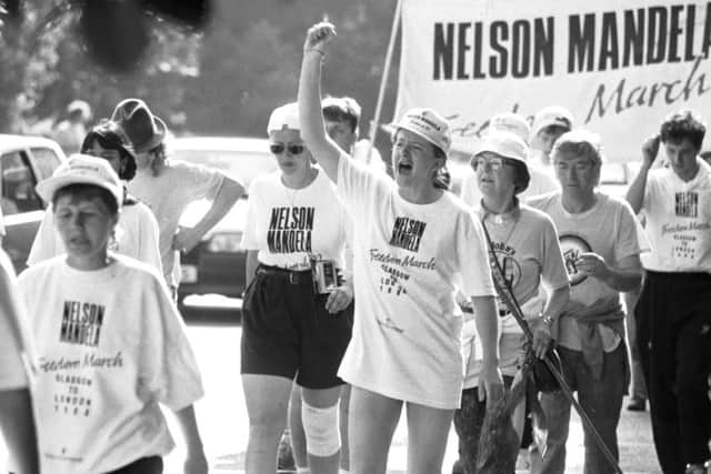 A woman raises her fist during the anti-apartheid Nelson Mandela Freedom March through Glasgow in June 1988. PIC: TSPL.