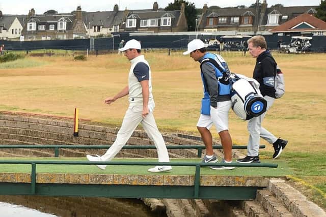 Rory McIlroy and caddie Harry Diamond walk across the Barry Burn on the 17th hole. Picture: Glyn Kirk/AFP/Getty
