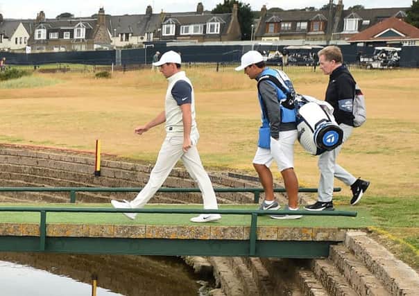 Rory McIlroy and caddie Harry Diamond walk across the Barry Burn on the 17th hole. Picture: Glyn Kirk/AFP/Getty