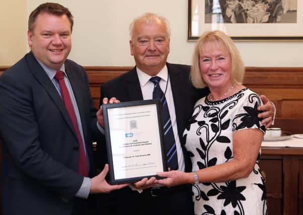 Sir Tom Devine, with his wife Catherine, receives the award from Nick Thomas-Symonds MP
