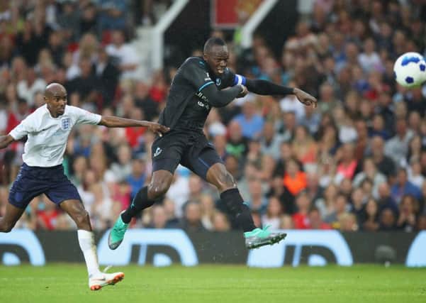 Usain Bolt, seen here taking a shot as Sir Mo Farah tries to close him down in a Soccer Aid match, has retired from sprinting and signed for an Australian football team