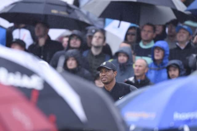 A forest of golf brollies surrounds Tiger Woods as he prepares to see off at the 5th. Picture Ian Rutherford
