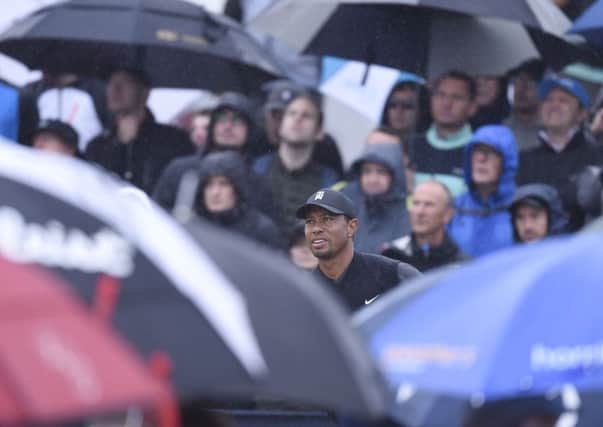 A forest of golf brollies surrounds Tiger Woods as he prepares to see off at the 5th. Picture Ian Rutherford