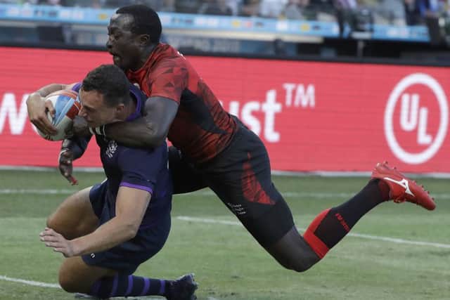 Scotland's Jamie Farndale scores in front of Kenya's Collins Injera during the Rugby Sevens World Cup. Pic: AP/Jeff Chiu