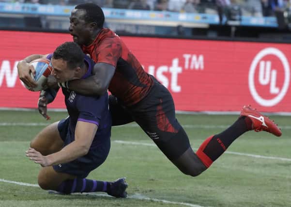 Scotland's Jamie Farndale scores in front of Kenya's Collins Injera during the Rugby Sevens World Cup. Pic: AP/Jeff Chiu