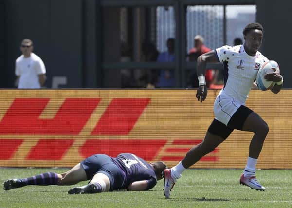 Carlin Isles of the US runs past Scotland's Robbie Fergusson to score at the Rugby World Cup Sevens in San Francisco. Picture: Jeff Chiu/AP