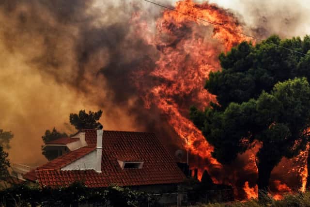 A house is threatened by a huge blaze during a wildfire in Kineta, near Athens, on July 23, 2018.
More than 300 firefighters, five aircraft and two helicopters have been mobilised to tackle the "extremely difficult" situation due to strong gusts of wind, Athens fire chief Achille Tzouvaras said. Picture: AFP PHOTO / VALERIE GACHEVALERIE GACHE/AFP/Getty Images.