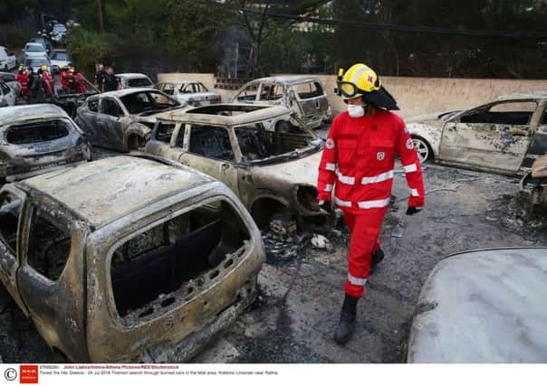 Firefighters search through burned cars near the Greek village of Mati (Picture: John Liakos/Intime/Athena Pictures/REX/Shutterstock)