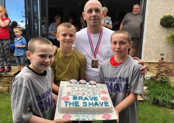 Robby Bain (12) and two of his friends from West Lothian Gymnastics Club - Ryan McGeorge and Lachlan Brown, after their head shave, with their coach.