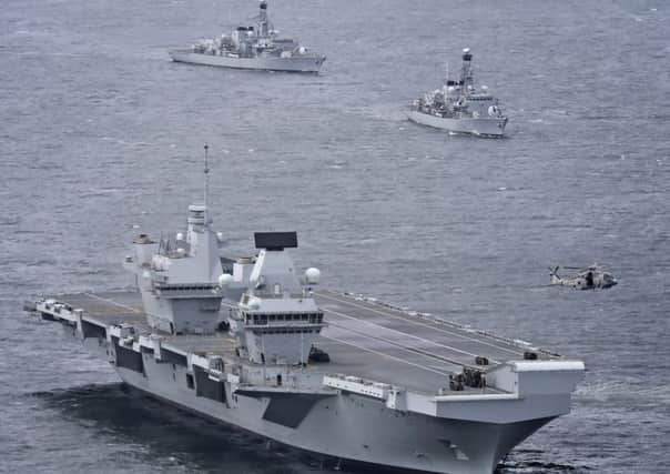 The Royal Navy's new aircraft carrier HMS Queen Elizabeth is guarded by two frigates,  HMS Sutherland and HMS Iron Duke (Picture: PA)