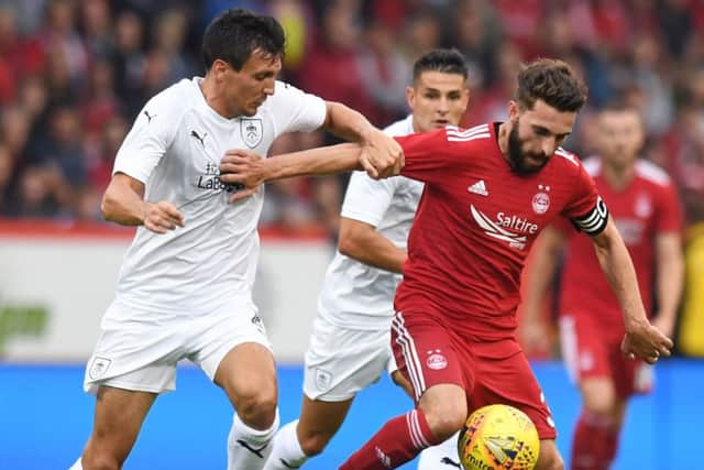 Graeme Shinnie holds off Burnley's Jack Cork. Pic: SNS/Craig Williamson