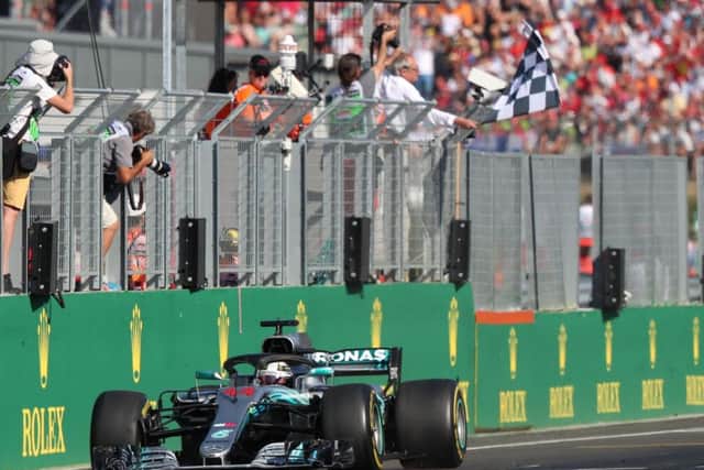 Lewis Hamilton crosses the finishing line to win the Hungarian Grand Prix. Picture: AFP/Getty.