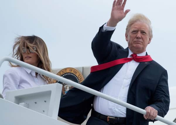 US President Donald Trump  waves with First Lady Melania Trump  as they board Air Force One. AFP PHOTO / JIM WATSONJIM WATSON/AFP/Getty Images