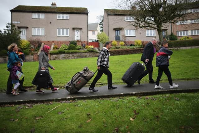 Syrian refugee families arrive at their new homes on the Isle of Bute in 2015. Other refugees housed in Glasgow are now at risk of eviction. Picture: Getty
