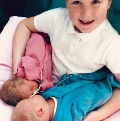 Millie Ashwood aged eight with her new brother and sister. Picture: SWNS