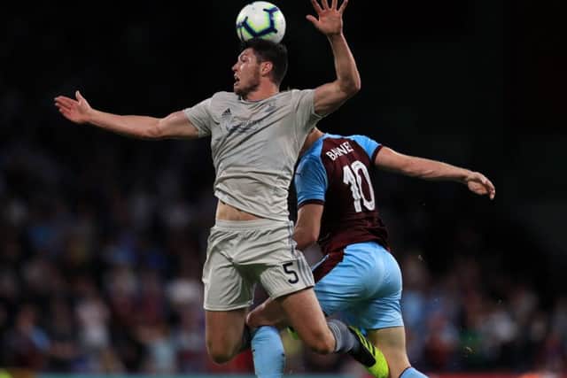 Scott McKenna (left) and Burnley's Ashley Barnes battle for the ball at Turf Moor. Picture: PA