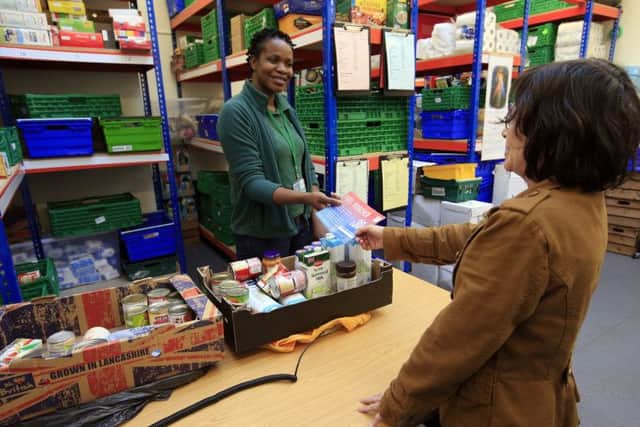 A foodbank manager gives a fuel voucher to a client at the Trussell Trust Brent Foodbank, Neasden, London. Picture: PA