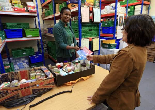 A foodbank manager gives a fuel voucher to a client at the Trussell Trust Brent Foodbank, Neasden, London. Picture: PA