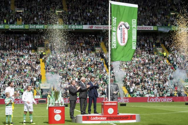 The Ladbrokes Premiership flag is unfurled by Danny McGrain after Celtic's title win last season. Picture: SNS Group